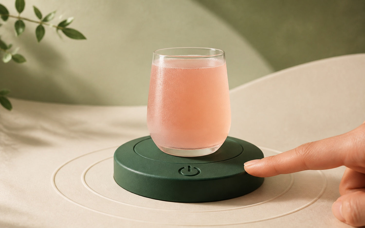 A guava-colored drink resting on a forest-green reset button as a visual metaphor for pressing pause
